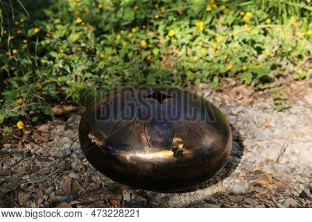 Steel Tongue Drum On Ground Outdoors. Percussion Musical Instrument