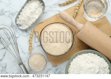 Leaven, Flour, Ears Of Wheat, Rolling Pin, Whisk And Water On White Marble Table, Flat Lay