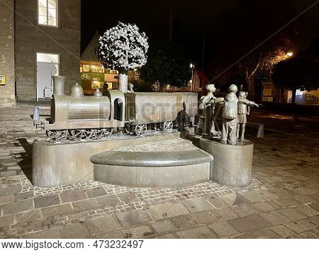 Group Of Bronze Statues Of Passengers And Train Next To Train Station. Diekirch, Luxembourg - Novemb