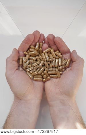 Guarana Capsules In Male Hands On A White Background. Capsules With Guarana Powder.natural Tonic.nat