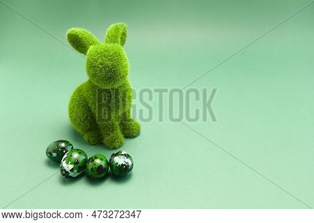 Mockup Easter Green Bunny, Rabbit With Blue Colored Chicken Quail Eggs On Blue Background. Copy Spac