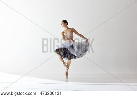 One Adotable Ballerina Holding Tutu And Dancing Over White Background