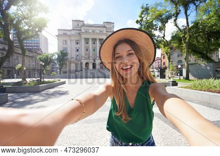 Tourism In Santos, Brazil. Happy Cheerful Traveler Girl Takes Self Portrait In Maua Square In The Hi
