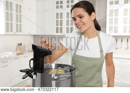 Woman Using Thermal Immersion Circulator In Kitchen. Sous Vide Cooking