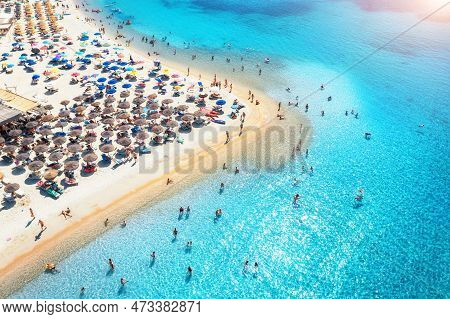 Aerial View Of Colorful Umbrellas On Beach, People In Blue Sea
