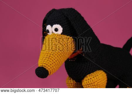 One Black And Red Dachshund Crocheted From Natural Wool And Cotton, Handmade Art. Close Up Portrait.