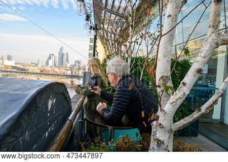 A Man Captures A Precious Moment As A Woman Takes In The Breathtaking View Of The Thames From The Ox