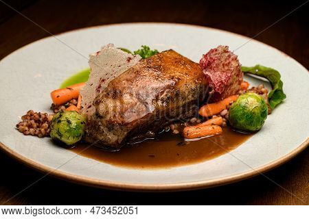 Close-up View On Dish Of Piece Of Baked Pork Meat With Buckwheat And Vegetables On Plate