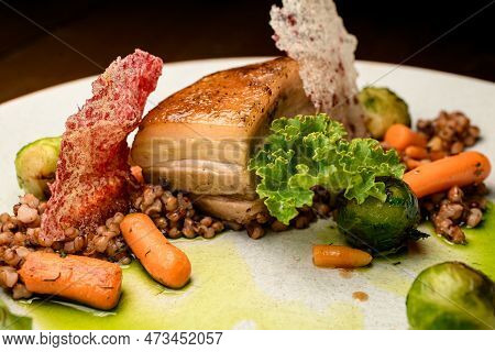 Close-up On Piece Of Baked Pork Meat With Buckwheat And Vegetables On Plate