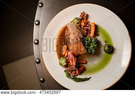 Top View On Plate With Piece Of Baked Pork Meat With Buckwheat And Vegetables On Table
