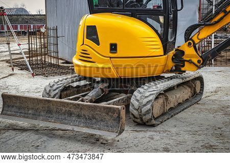 Mini Excavator Digs A Trench At A Construction Site. Laying Of Underground Sewer Pipes And Communica