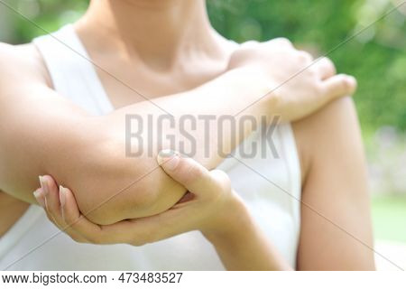 Woman Touching The Elbow With Elbow Pain And He Relieves Pain With Massage. Health And Healing Conce