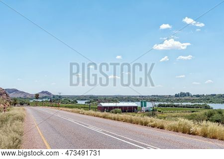 Upington, South Africa - Feb 24, 2023: A Road Scene, With Buildings And The Flooded Orange River, On