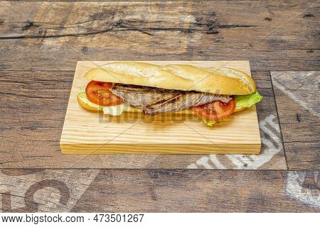 Beef Sirloin Pepito With Peppers And Melted Cheese With Tomato And Lettuce On Pine Wood Board