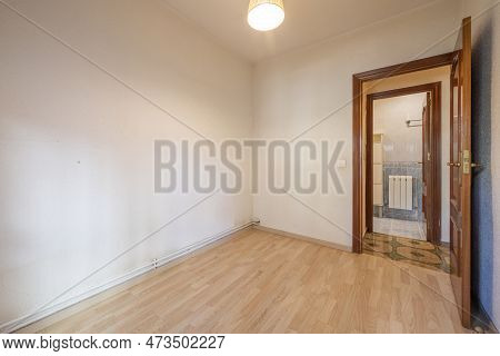 Small Empty Room With A Laminate Floor And A Sapele Wood Access Door Next To A Bathroom With A Radia
