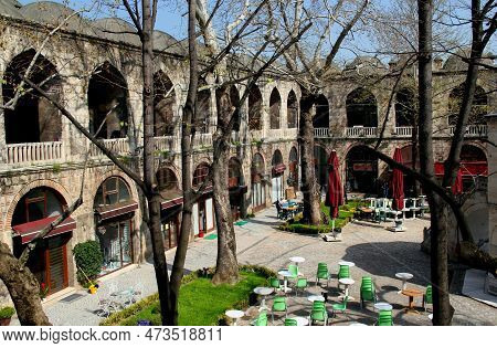 Courtyard View Of The Two-story Koza Han Market With Shops Inside Against A Clear Blue Sky In Bursa,
