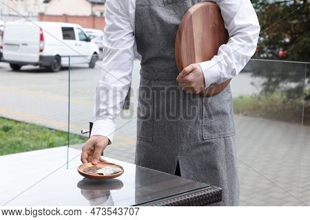 Waiter Taking Tips From Wooden Table In Outdoor Cafe, Closeup