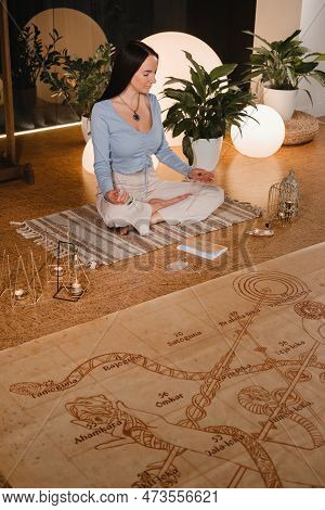 A Young Woman Sits In The Lotus Position Before The Start Of The Game Leela And Holds A Game Cube In