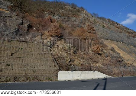 Reinforcing Slope With A Steel Net Anchored Deep Into Rock. Rows Inclined Fences With Massive Nettin