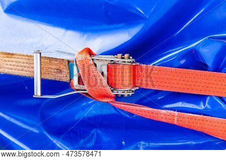 A Weight Belt With A Ratchet Lock Holds The Load Wrapped In Blue Tape.