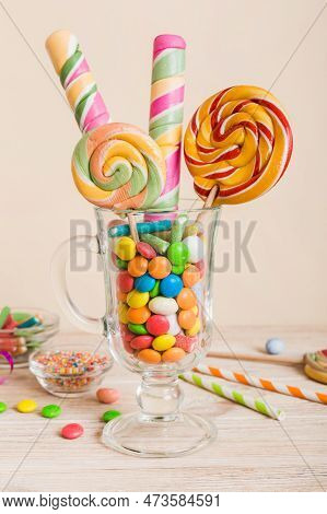 Colorful Candies In Cup On Table On Light Background Background. Large Swirled Lollipops. Creative C