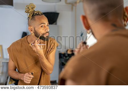Black Male Gay Applying Make Up Looking Mirror Standing Back To Camera. Stylish Homosexual Man In Dr