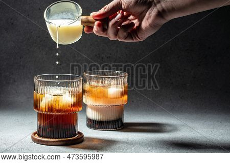 Making Milk Bubble Tea With Tapioca Pearls. Freeze Motion Splash Drops Of Drink On A Dark Background