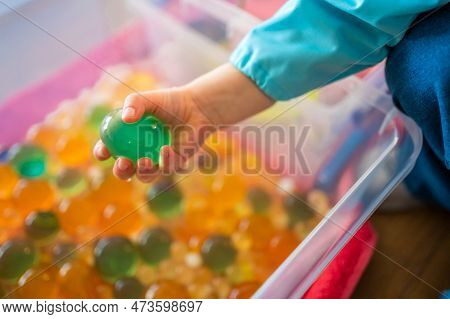 Little Girl Playing With Sensory Water Beads, Hydrogel Balls. Sensory Development And Experiences, T
