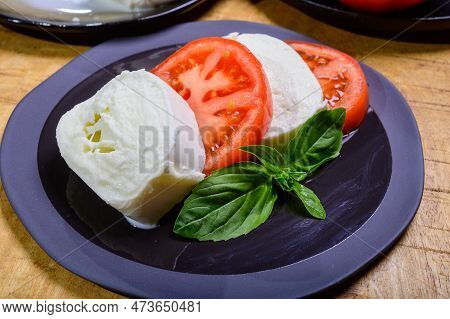 Sliced White Ball Of Italian Soft Cheese Mozzarella Di Bufala Campana Served With Fresh Green Basil