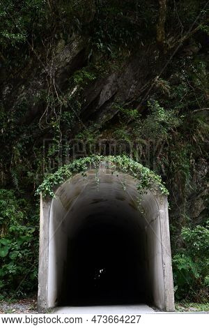 Vertical Shot Of An Entry Of A Long And Dark Tunnel In The Mountains At Tianxiang, Xiulin