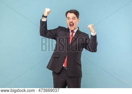 Portrait Of Excited Extremely Happy Man Standing With Clenched Fists, Celebrating His Victory, Screa