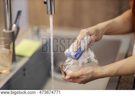 Hands Doing Dishes In Sink. Close Up Of Hands Washing Glass.