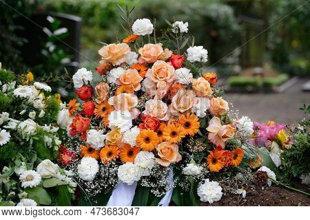 Stylish Funeral Flowers Of White Carnations, Orange Gerbera And Red And Pink Roses On A Grave After 