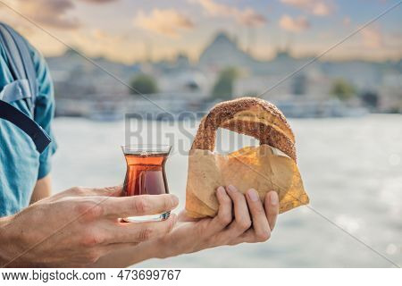 Man In Istanbul Having Breakfast With Simit And A Glass Of Turkish Tea. Glass Of Turkish Tea And Bag