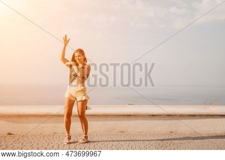 Woman Summer Dance. Silhouette Of A Happy Woman Who Dances, Spins And Raises Her Hands To The Sky. A