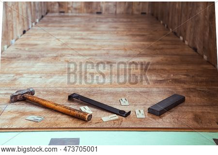 Laying Laminate Flooring On The Loggia. The Laminate Laying Tool Lies On Top Of The Installed Lamina
