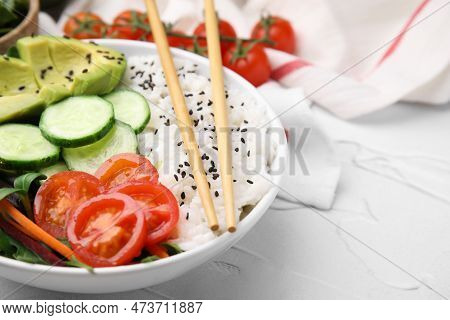 Delicious Poke Bowl With Vegetables, Avocado And Mesclun On White Table, Closeup