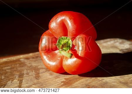 Red Bell Pepper On A Wooden Board. Bright, Healthy Vegetables. A Constrate Photo Of A Bell Pepper Wi