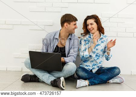 Portrait Of Happy Young Couple Using Laptop On Gray Background