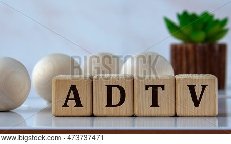 Adtv (average Daily Trading Volume) - Acronym On Wooden Cubes Against The Background Of Light Balls 