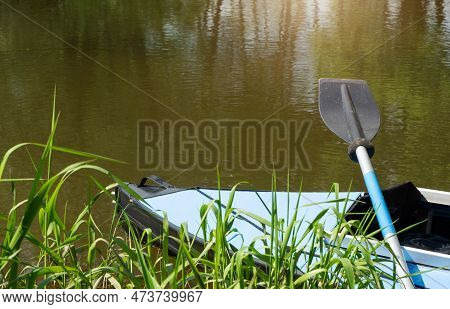 Tourist Canoes With Paddles Stand On The River Coast In Summer On A Water Hike. Rafting On Inflatabl