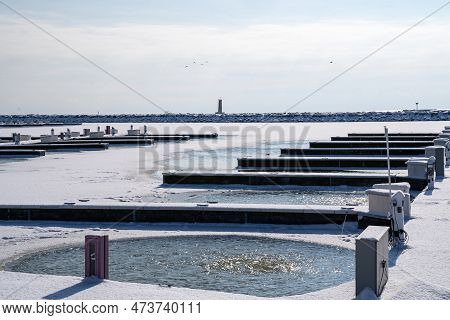 View Of The Docks And Boat Slips On Lake Michigan, With The Sheboygan Lighthouse In The Distance, Ta