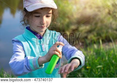 Girl Uses A Remedy For Mosquitoes And Biting Insects In Nature. Protection Of The Skin From Tick Bit