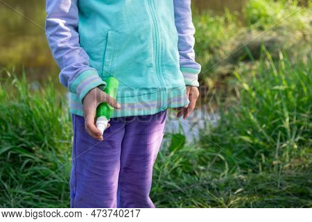 Girl Uses A Remedy For Mosquitoes And Biting Insects In Nature. Protection Of The Skin From Tick Bit