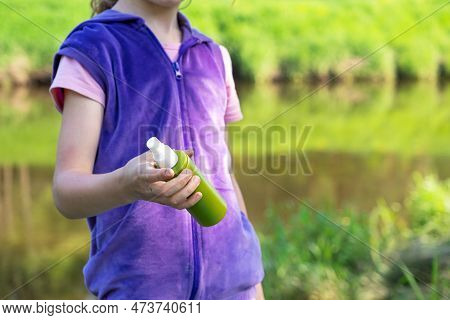 Girl Uses A Remedy For Mosquitoes And Biting Insects In Nature. Protection Of The Skin From Tick Bit