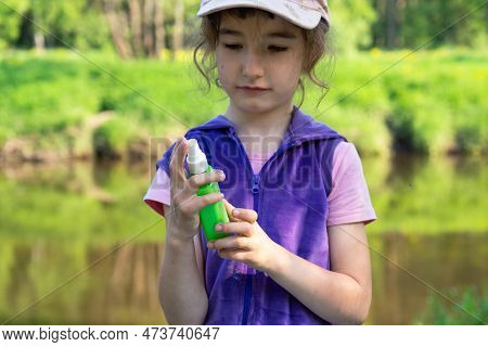 Girl Uses A Remedy For Mosquitoes And Biting Insects In Nature. Protection Of The Skin From Tick Bit