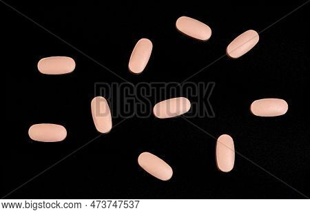 Scattered Unspecified Pink Pills On A Black Background