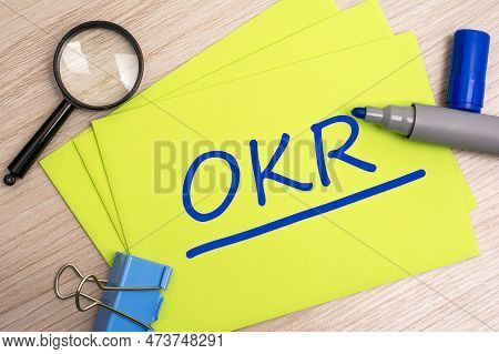 Okr - Objectives And Key Results - Acronym Text Concept With Marker On Yellow Business Card