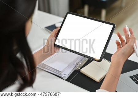 View Over Shoulder Of Businesswoman Hands Holding Digital Tablet. White Screen For Graphic Display M