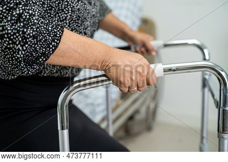 Asian Lady Patient Use Walker To Help Waliking Support For Orthopedic Lumbar.
